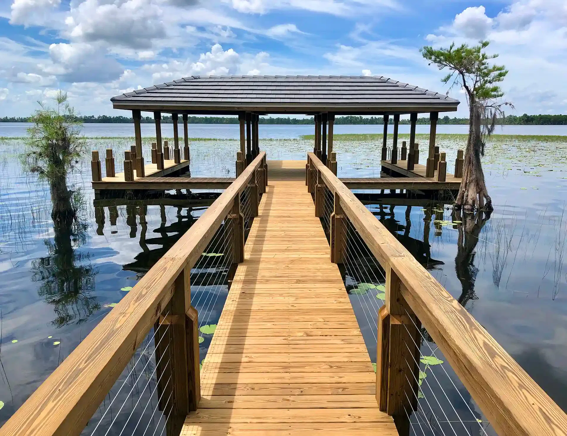 Photo of a walkway leading to a boat house with two boat slips. 