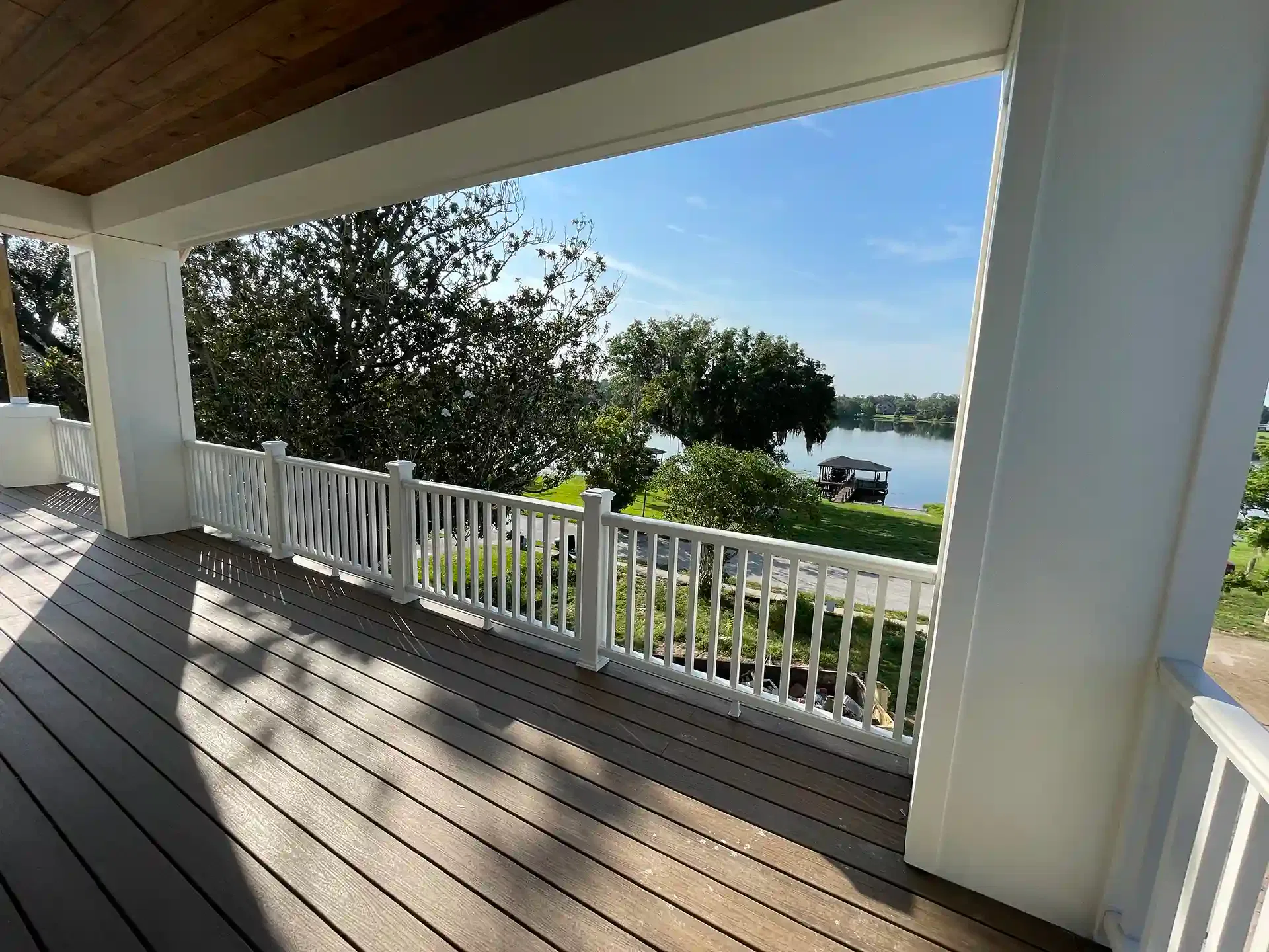 Photo of a covered deck overlooking the water with a boat house.