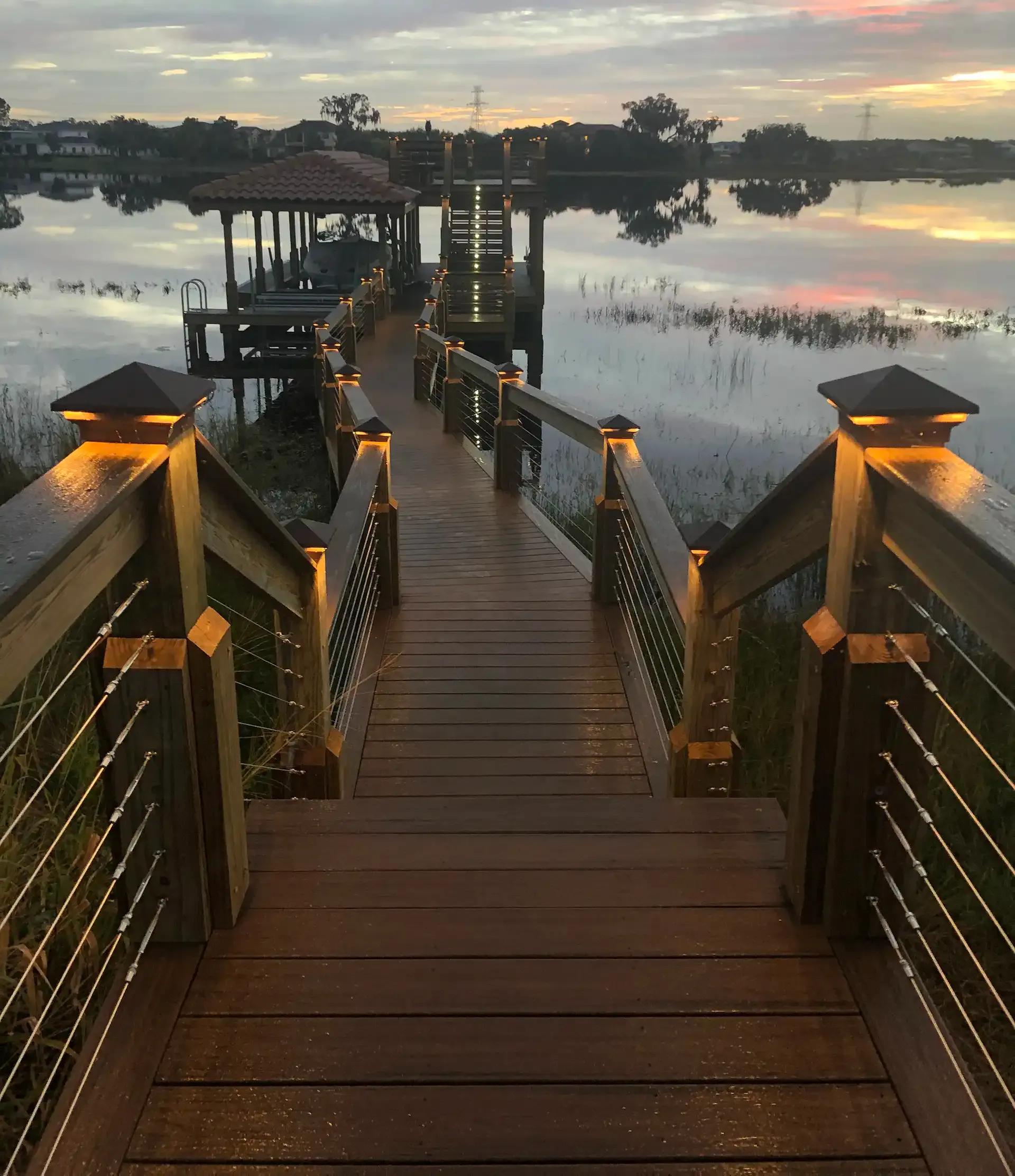 photo of a lighting walkway leading out to a boathouse with dock lighting