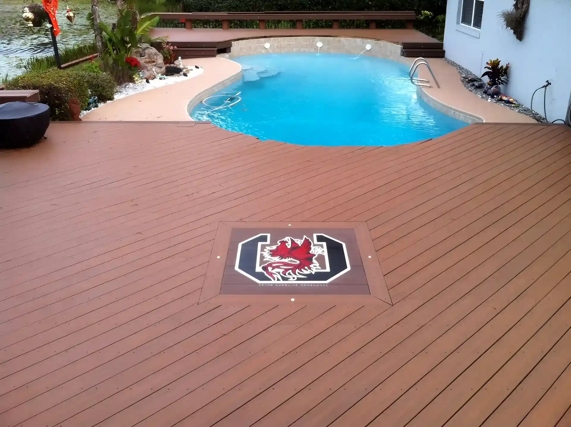 Photo of a deck with a curved area to accommodate the curved edge of a pool.
