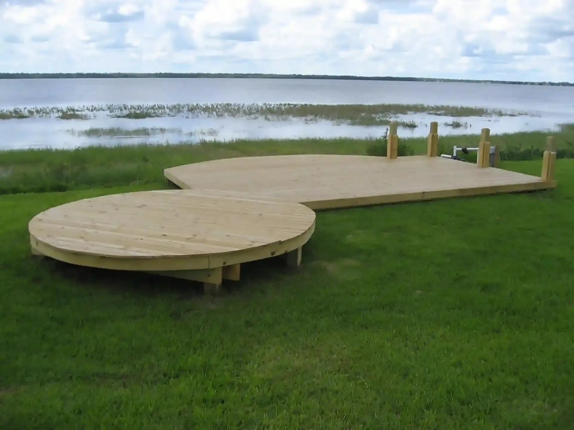 Photo of two freestanding decks, a circular curved deck and another with a curved front facing the shoreline.