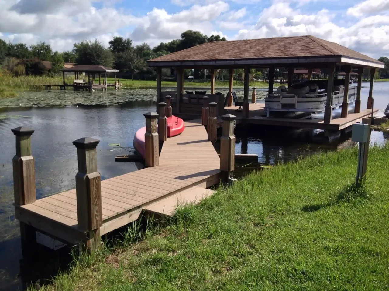 Photo of a boat house with a walkway leading from land to dock.