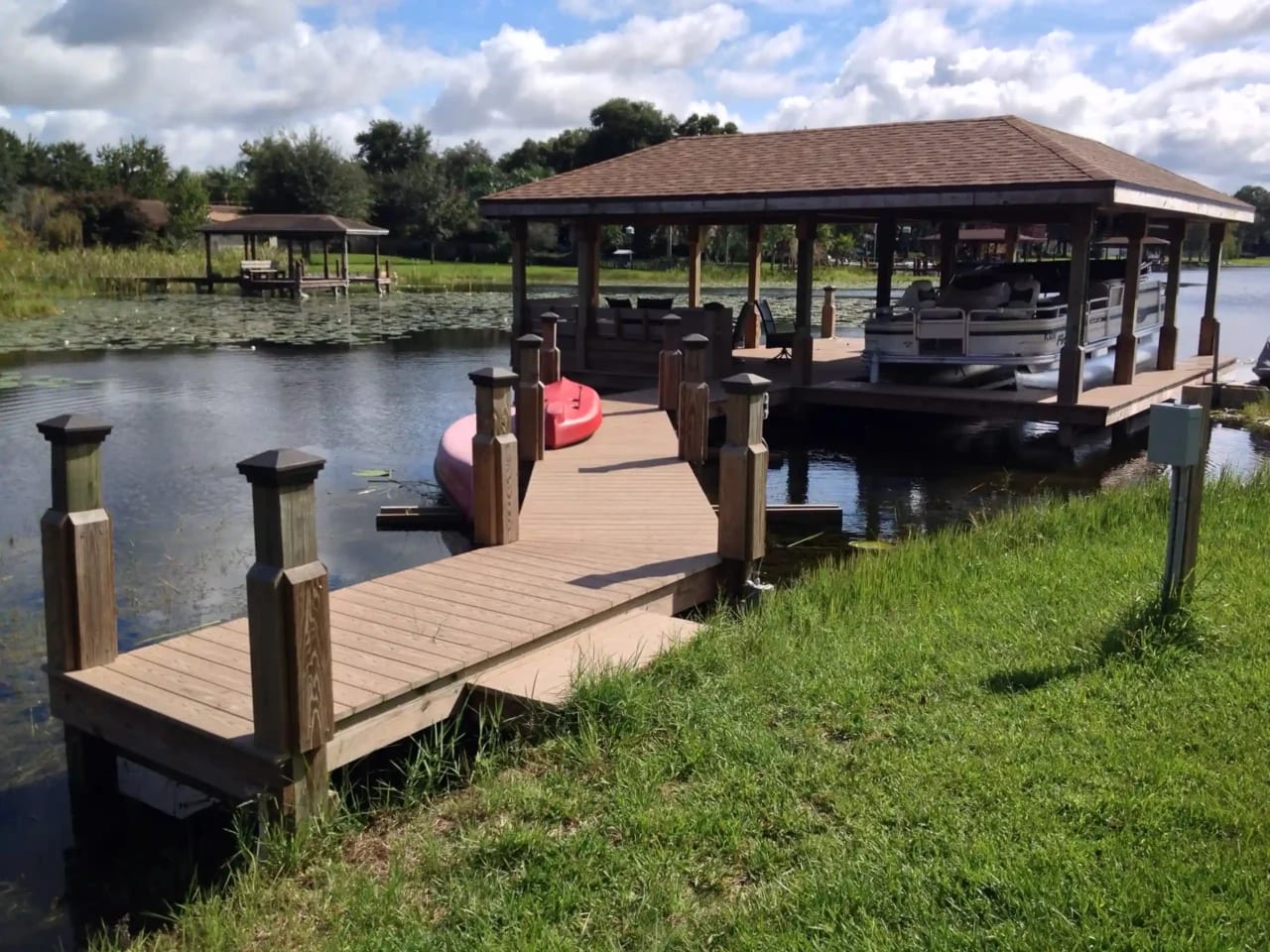 Photo of a boat house with a walkway leading from land to dock.